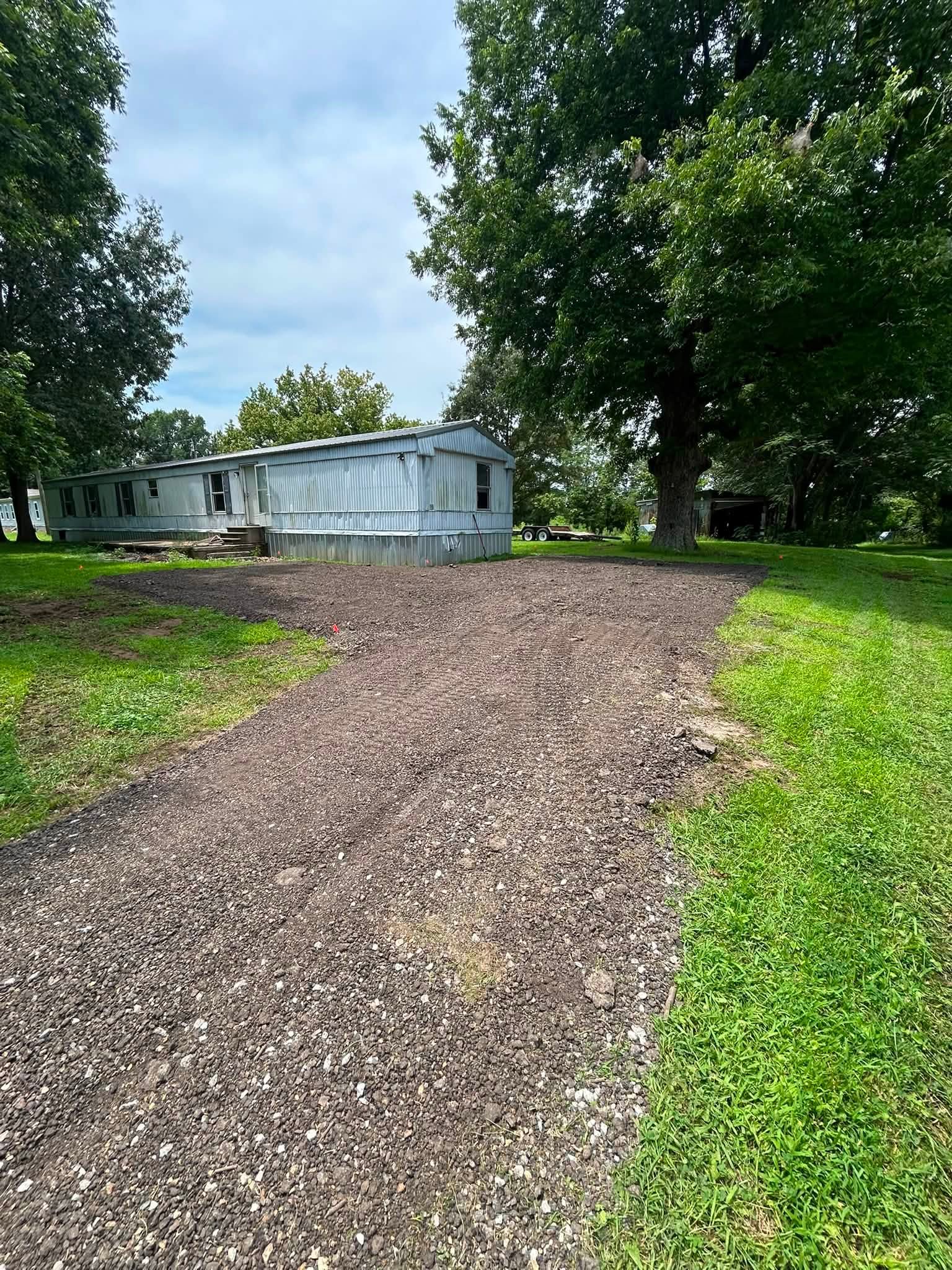 Finished gravel driveway and parking area beside a rural home